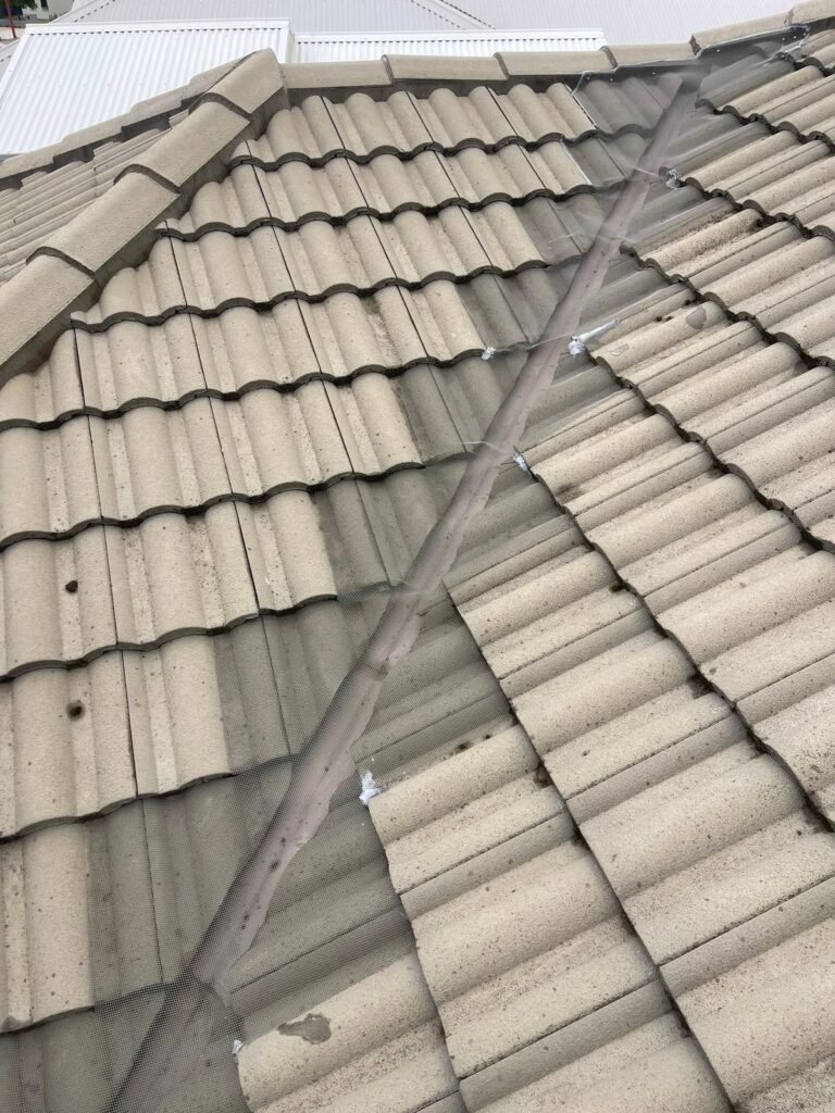 Grey tiled roof valley with mesh gutter guard